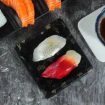 Close-up of sushi in a black WL-0.1 maple leaf tray with clear lid