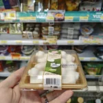 WL-0.1 small gold sushi tray package displayed by a shopper in a retail store