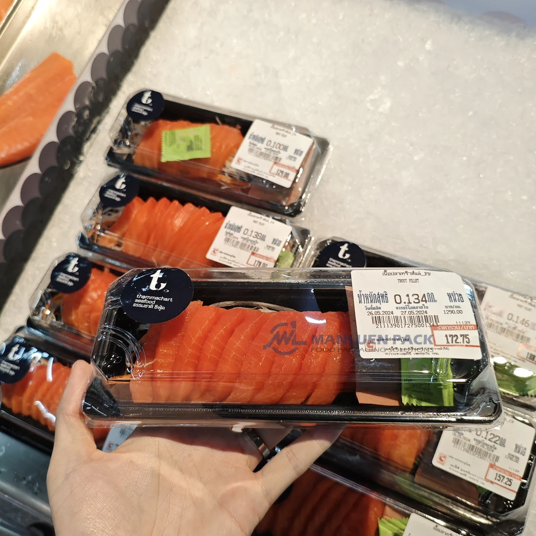 Shopper holding a packaged WL-01 sushi tray in a refrigerated retail display