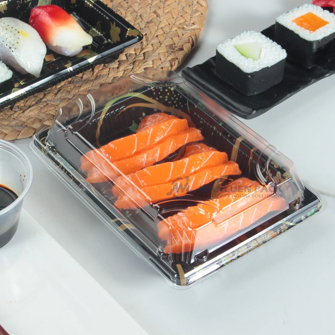 Salmon sushi arranged in a black WL-03 tray with a transparent lid in a dining setting
