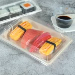 Covered WL-05 bagasse sushi tray with assorted sushi in a tabletop setting