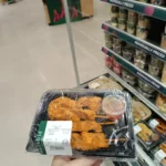 Handheld WL-05 tray packed with a prepared takeaway meal and sauce cup