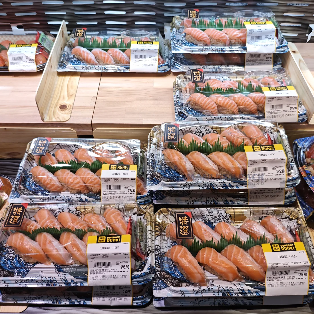 Multiple covered WL-07 sushi trays arranged in a supermarket seafood counter