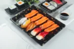 WL-11 covered sushi tray with assorted nigiri and rolls in a tabletop setting