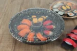 WL-64 sushi packaging shown in a covered round sushi platter tabletop view
