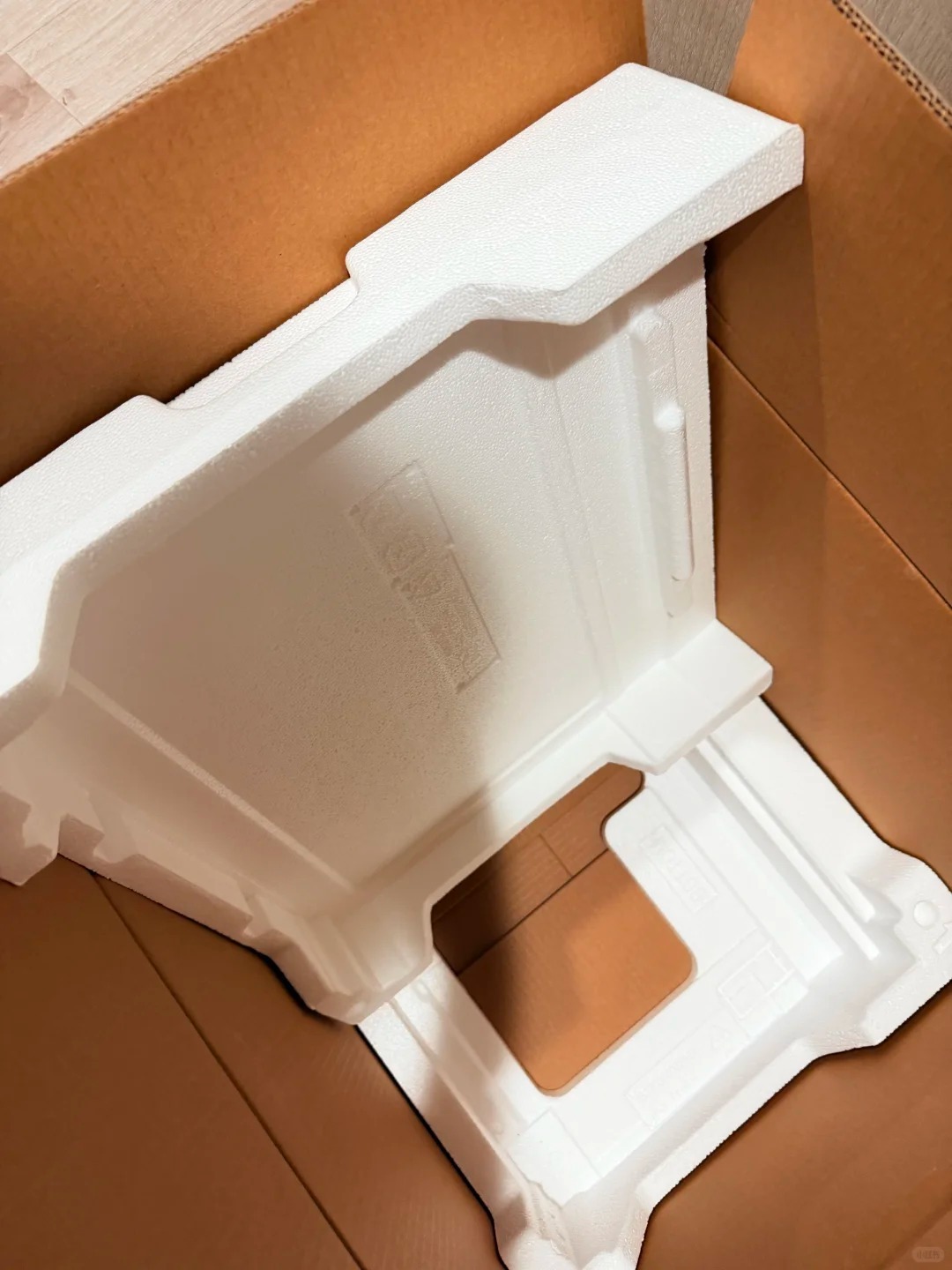 White molded EPS foam packaging inserts placed inside a cardboard shipping box