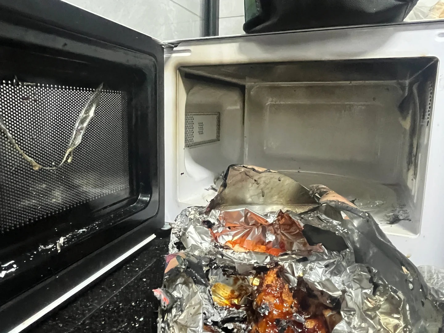 Is Aluminum Foil Safe for Food Packaging? A 2026 Buyer’s Guide 6 Aluminum foil wrapped food inside a microwave showing the risk of improper foil use during heating.