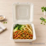 Bagasse clamshell food container with noodles, dumplings and vegetables