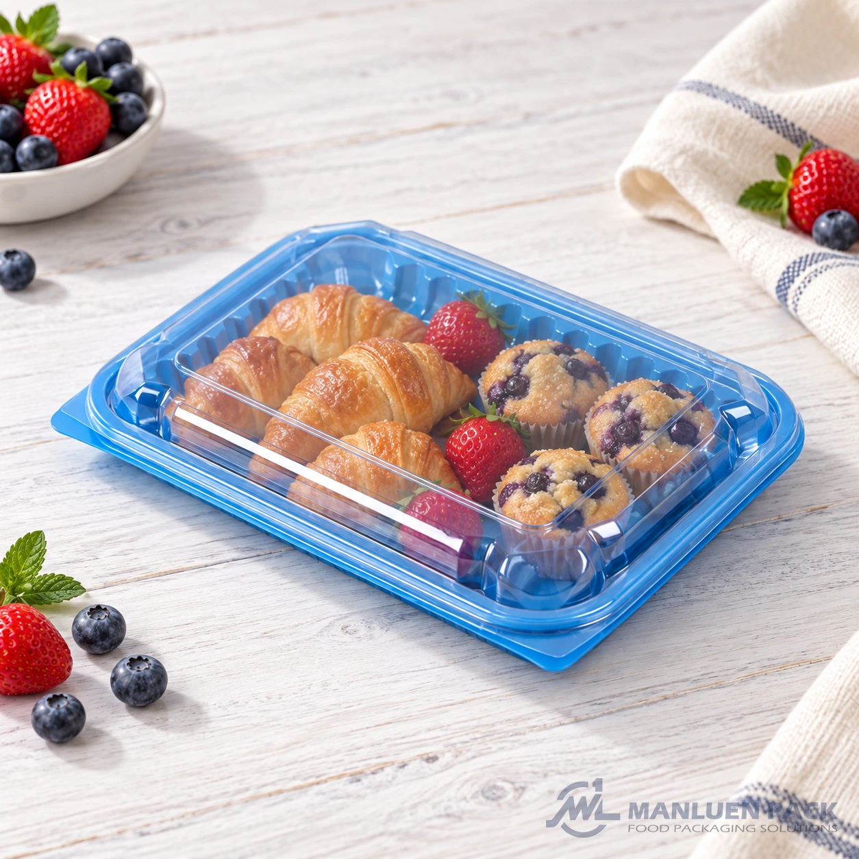 WL-CM011 closed plastic hinged clamshell food container filled with croissants, muffins and berries in angled view