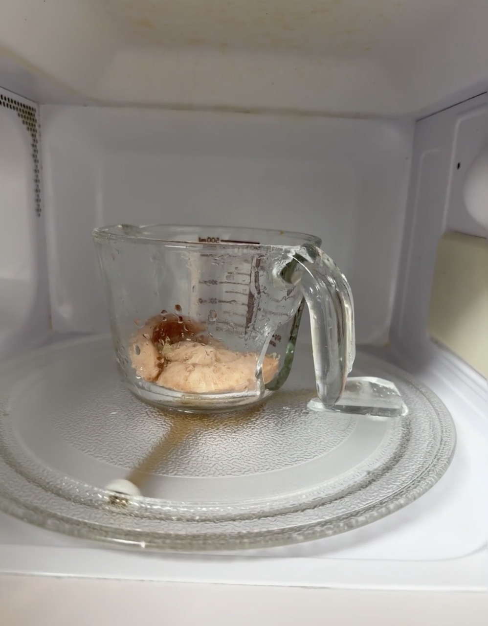 Can You Heat Up Food in a Glass Container in the Microwave? 4 Alt TextBroken glass measuring cup with food inside a microwave