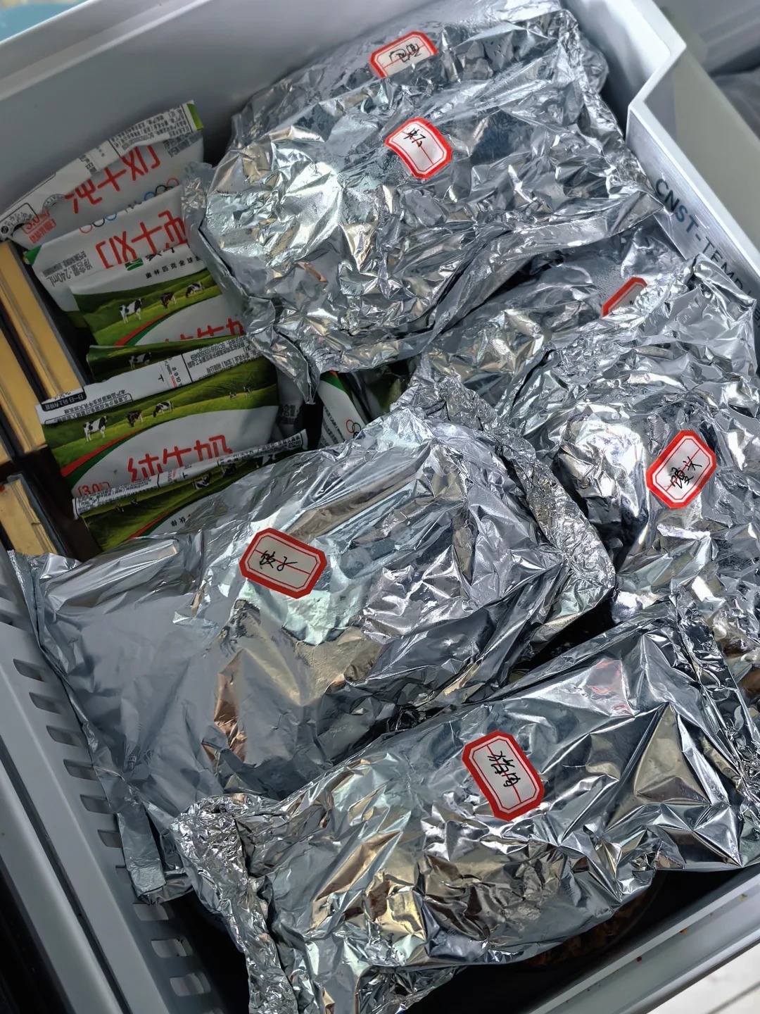 Is Aluminum Foil Safe for Food Packaging? A 2026 Buyer’s Guide 5 Multiple food portions wrapped in aluminum foil inside a refrigerated storage container.