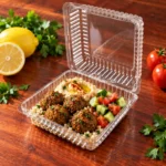 WL-CM002 open plastic hinged clamshell food container filled with falafel, couscous and hummus in angled view